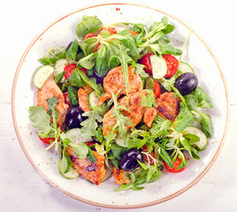 Fresh salad with chicken, arugula, cucumber  and tomato.