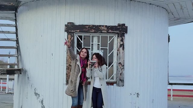 two young women are photographed on the background of the lighthouse.slow motion