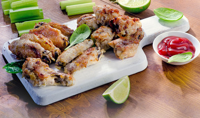 Chicken wings on wooden cutting board.