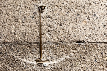 old antique brass hook catch on a stone wall texture background