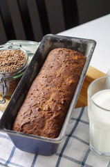 Homemade gluten free bread with linseed flour and psyllium husk. Jug and glass of milk