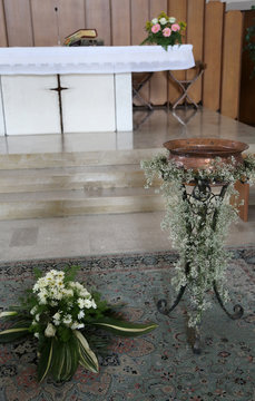 white altar of the Christian church with the baptismal font duri
