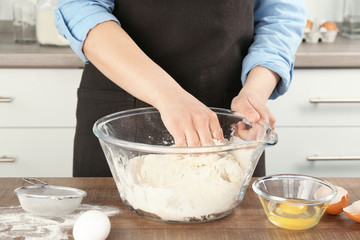 Female chef making dough in kitchen