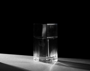 Bottle of modern male perfume on dark background