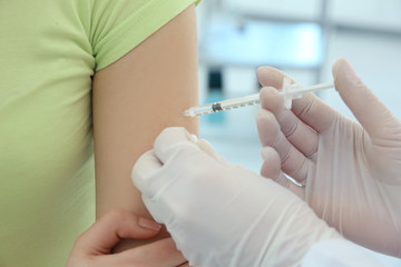 Doctor vaccinating patient in clinic, closeup