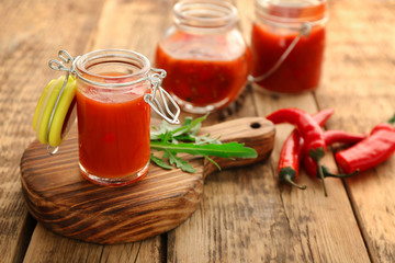 Composition with tasty chili sauce on wooden table