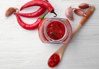 Fotobehang Composition with tasty chili sauce on wooden table © Africa Studio