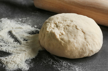 Raw dough on dark textured table, closeup