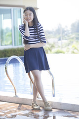 Obraz premium portrait of asian teen age standing beside swimming pool relaxing emotion