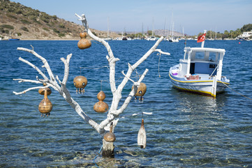 Scenic view of Mediterranean coastline with decorative gourds in whitewashed tree on the shore of a beach in Bodrum, Turkey © lazyllama
