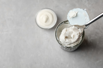 Coconut cream in spoon on grey background