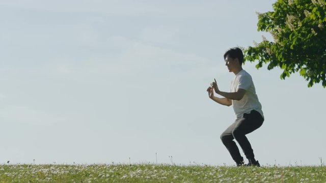 Young man doing martial arts training outdoors in the countryside