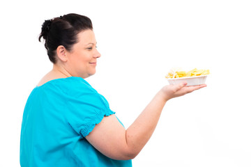 übergewichtige frau schaut auf eine schale pommes frites