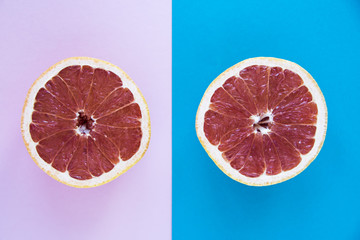Cut in half a grapefruit on a pink and blue background