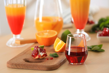 Glasses of Tequila Sunrise cocktail with ingredients on kitchen table