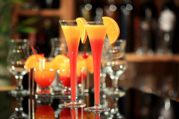 Tequila Sunrise cocktails in glasses on bar counter
