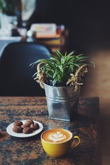 A cup of coffee with some cookie in coffee shop.