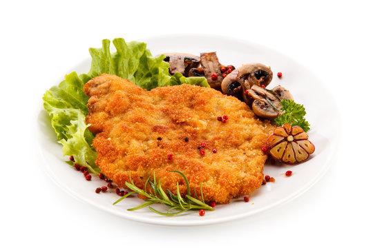 Fried pork chop with mushrooms on white background