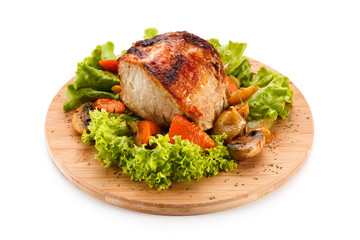 Roast ham with vegetables on wooden desk