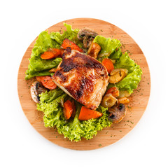 Roast ham with vegetables on wooden desk