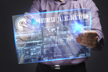Business, Technology, Internet and network concept. Young businessman working on a virtual screen of the future and sees the inscription: Business transformation © photon_photo