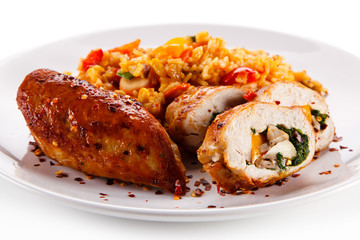 Stuffed chicken fillet with rice and vegetables on white background