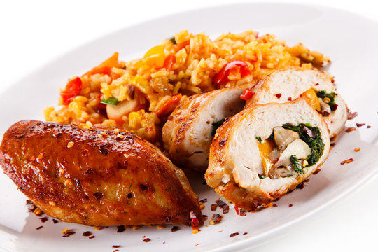Stuffed chicken fillet with rice and vegetables on white background