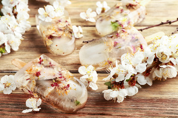 Homemade ice pops with flowers on wooden background