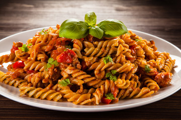 Pasta with tomato sauce on wooden table