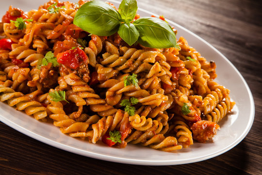 Pasta with tomato sauce on wooden table