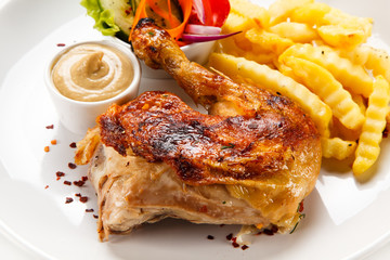 Roast chicken leg with french fries on white background