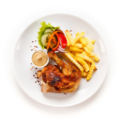Roast chicken leg with french fries on white background
