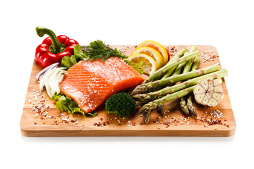 Fresh raw salmon with asparagus on cutting board on white background