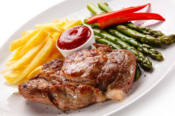 Grilled steak with french fries and asparagus on white background