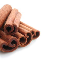 Heap of cinnamon sticks isolated on white, closeup