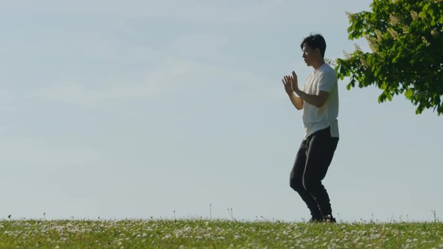 Close up of man doing tai chi outdoors in the countryside