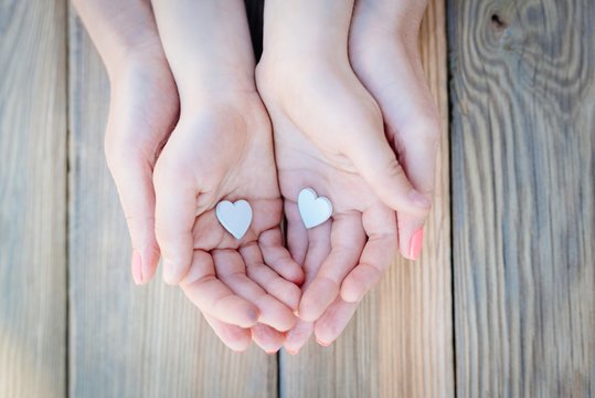 Child and mother's hands holding heart
