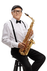 Obraz na płótnie Canvas Mature jazz musician with a saxophone sitting on a chair
