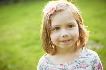Portrait of a smiling little girl outdoors. Close-up