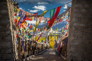 Fototapeta na wymiar Colourful Buddhist prayer flags on a bridge above Indus river in the Himalayan mountain, Leh, Ladakh, India
