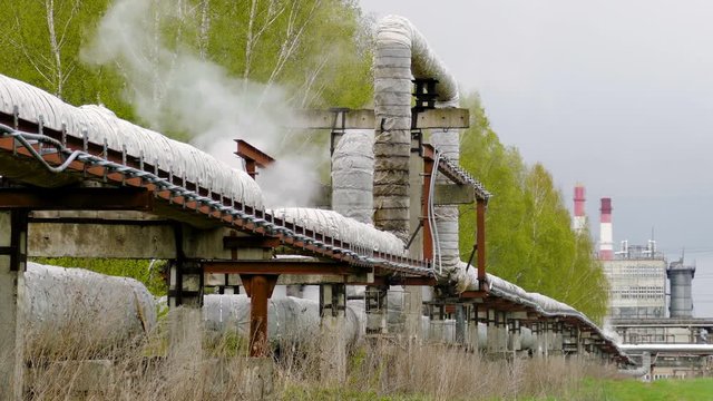 industrial pipelines on pipe-bridge from which emanate jets of steam