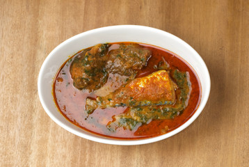 A bowl of ewedu and gbegiri mixed with beef and fish condiments
