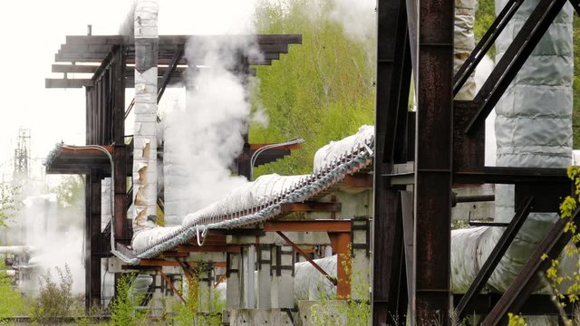 industrial pipelines on pipe-bridge from which emanate jets of steam
