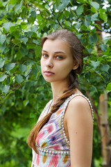 Portrait of a beautiful girl in a green summer day park