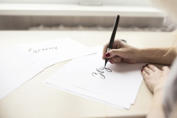 Hands writing with brush and ink, lettering