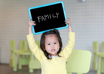 Cute little child girl holding blackboard showing text 