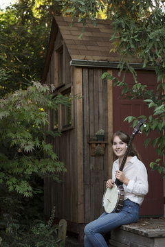 Woman holding banjo outdoors