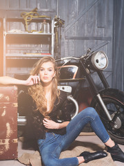 Plakat sexy girl biker with suitcase at motorcycle hold mobile phone