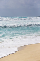 Beach view in the tropical paradise. Focus point on the foam in front 