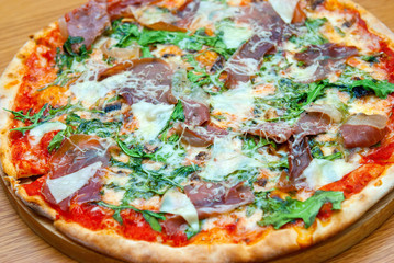 Pizza with arugula and parma ham